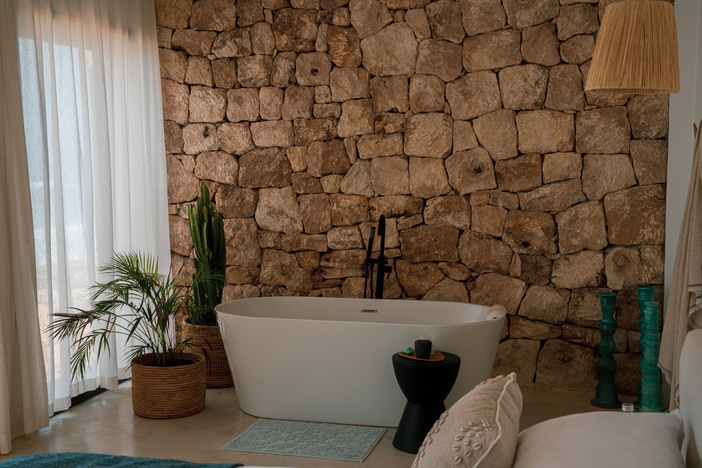 Salle de bain de la Suite, baignoire îlot sur mur de pierre