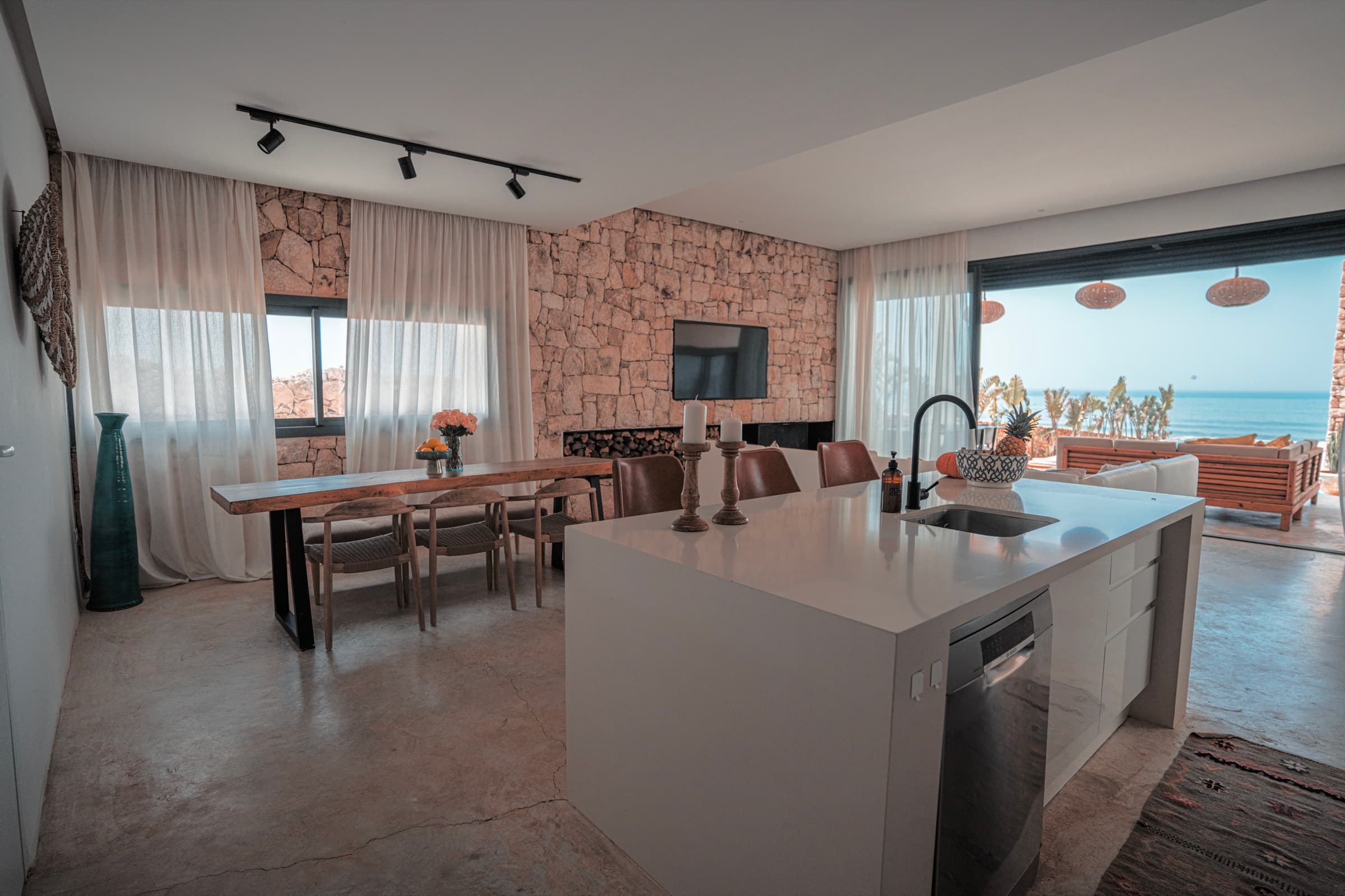 Cuisine équipée avec îlot central, océan en enfilade