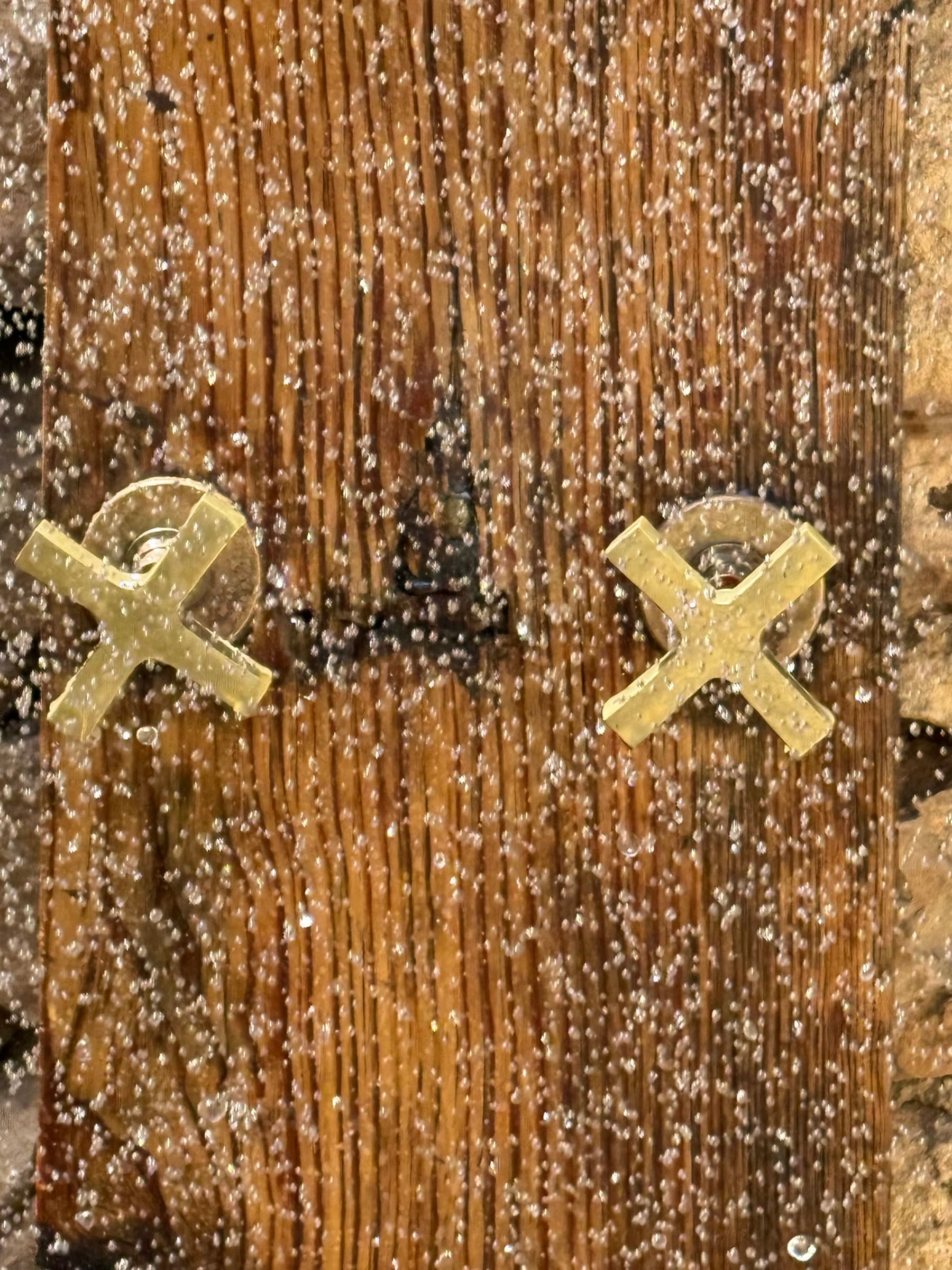 Les poignées en laiton de la douche extérieure, sur bois patiné